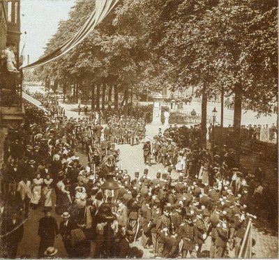 Straatbeeld. Spoorlaan ter hoogte van het Stationsplein. Militaire muziekwedstrijd 17, 18 en 19 juni 1905. Militaire parade. (Origineel is een stereofoto.)