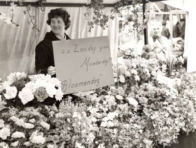 Marktvrouw tussen de bloemen, Veghel ca. 1965