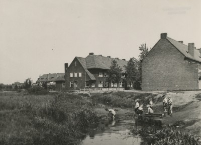 Kinderen vissen met schepnetjes in het riviertje de Gender, bij de Sophia van Würtemberglaan. Strijp 1945