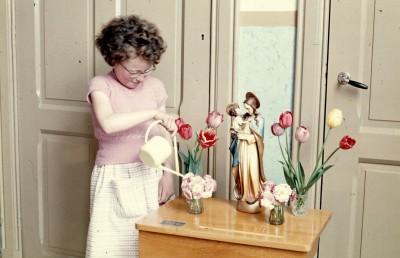 Maria Smits geeft de plantjes water bij het Mariabeeld in de klas van de Mariaschool, Den Dungen 1957