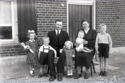 Familiefoto uit Grave, het meisje links houdt haar pop stevig vast.