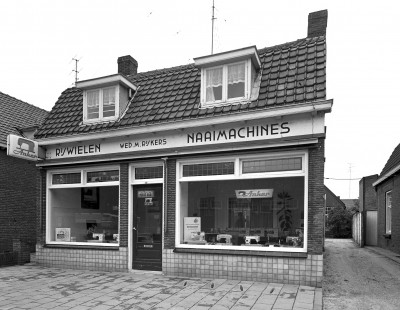 Pand en winkel van Wed. M. Rijkers, Rijwielen en Naaimachines, Veghel ca. 1965