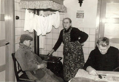 Bij de kachel in de keuken is het behaaglijk warm, Lithoijen ca. 1960