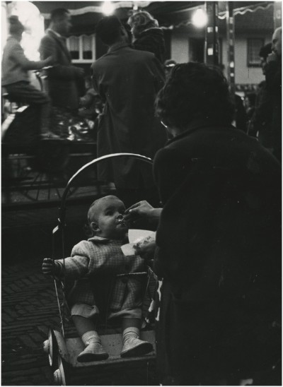 Een kindje in een buggy krijgt een ijsje. Eindhoven, 1970.