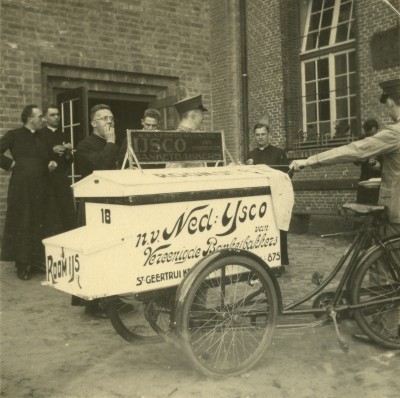 Een onverwachte traktatie op een ijsco bij het zilveren priesterjubileum van monseigneur F.A.J.A. Goijaerts, met de bakfiets gebracht op de binnenplaats. Sint-Michielsgestel, 1934
