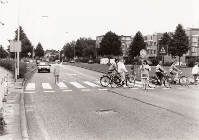 Verkeersbrigadiers begeleiden kinderen bij het oversteken van het zebrapad van de Willem de Zwijgerweg. Best, 1990