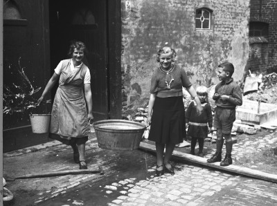Aan de was in de Lombardstraat, bij de schuur van de familie Dekkers, Ravenstein 1935 (foto: Fotopersbureau Het Zuiden, collectie BHIC, nr. 1665-000195)