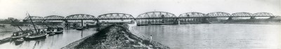 Verkeersbrug, stuw en sluizen met scheepvaart in de Maas bij Grave. Foto is genomen vanuit het westen (stroomafwaarts). (foto: fotostudio Jean Smeets, collectie BHIC, nr. 1907-008818)