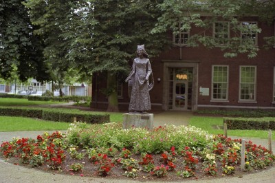 Standbeeld van hertogin Johanna, hier nog achter het Jan Cunen, Oss 1987 (standbeeld: Niek van Leest 1979, foto: A.H. van der Stappen, collectie BHIC, nr. 1699-000586)