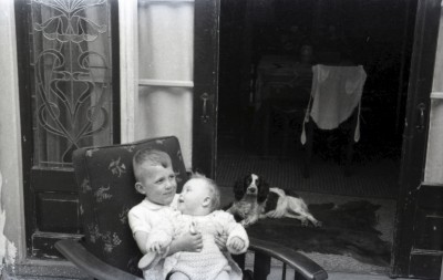 Een jongen met een baby op schoot, en een hond. Grave, ?