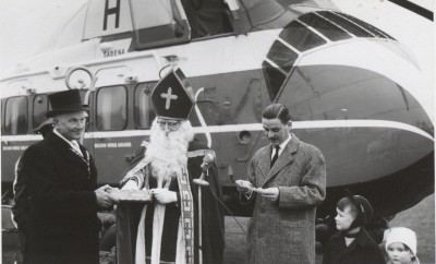 Sinterklaas doet een prijsuitreiking (voor een helicoptervlucht) bij de helicopter waarmee hij naar Boekel is gekomen. Boekel, 1958