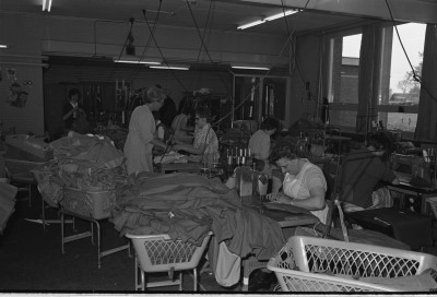 Dames aan het werk tussen stapels en stapels stof, Geffen 1964 (foto: Fotopersbureau Het Zuiden, collectie BHIC nr. 1636-000369)