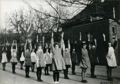 Meisjes gymnastieken in schort en maillot in de buitenlucht, Esch 1937 (foto: beeldcollectie Jansen, collectie BHIC nr. 1928-000036)