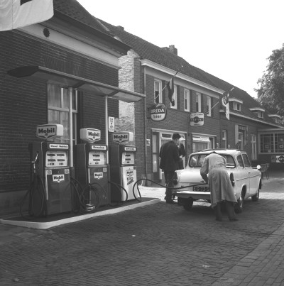 Tankstation 'Mobil oil' Willekens in Sint-Michielsgestel. De man in stofjas is Toon Habraken, de pompbediende. Sint-Michielsgestel, 1963