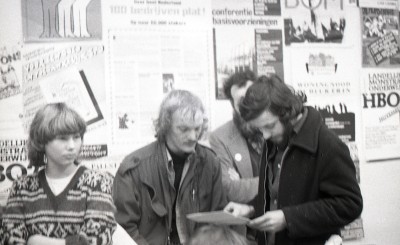 Straatbeeld met verschillende actieposters, met op de voorgrond Arnold Karskens. 's-Hertogenbosch, ca. 1975-1985