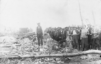 Manus Manders verloor zijn dochter tijdens de stormramp en staat op de puinhoop van zijn boerderij, met daarnaast: bezoekers uit Langenboom, Zeeland 1925 (foto: fotograaf onbekend/Willem Keeris, collectie BHIC nr. 1698-002195)