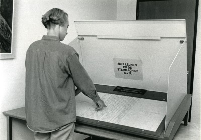 Een persoon gebruikt een stemmachine. Uden, 1995