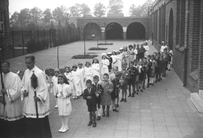 Jongens in nette kleding met korte broek, tijdens hun communie. Vught, 1944