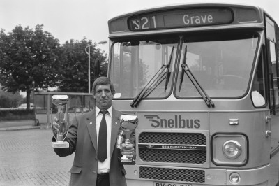 Streekbuschauffeur voor lijn S21 naar Grave met zijn eerder gewonnen bokalen voor beste chauffeur (foto: J. Smeets, collectie BHIC nr. 1907-006168)