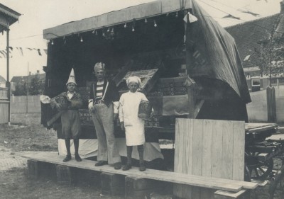 Drie personen voor de koekkraam op de kermis