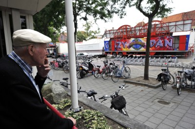 Bewoner van zorgcentrum Sint-Catharina kijkt naar de opbouw van de kermis, Bergen op Zoom 2010 (foto: Thom van Amsterdam, collectie West-Brabants Archief nr. AM2010-00616)
