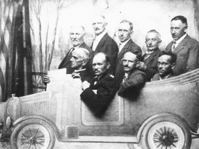  "Met spoed naar kermis 1935": Groep mannen achter een decor van een automobiel bij een kermisfotograaf, Waalwijk 1935 (foto: Streekarchief Langstraat Heusden Altena nr. WAA42014)