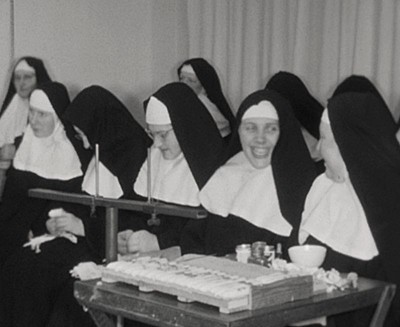 Zusters tijdens de Sinterklaasviering in klooster Manna Absconditum, Breda jaren 60 (Filmstill uit de film over de slotzusters van Breda: Erfgoedcentrum Nederlands Kloosterleven, archief Benedictinessen van het H. Sacrament (AR-Z013), filmcollectie AVB-Z013-034)