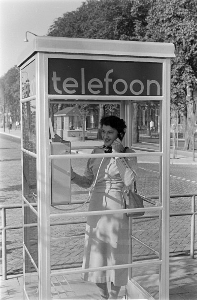 Telefoneren vanuit een telefooncel, Oss ca. 1960 (foto: Daan Scholte, collectie Stadsarchief Oss nr. DSN0736_24800)