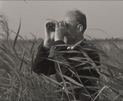 Bernard van Dooren met een verrrekijker op zoek naar vogels, ca. 1945