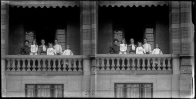 Drie vrouwen en drie kinderen poseren op het balkon.