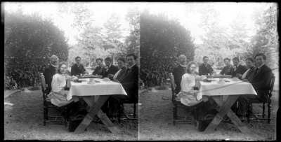 Lucien Dor zit met familieleden buiten aan tafel. Op tafel staat een Limburgse vlaai., omstreeks 1920